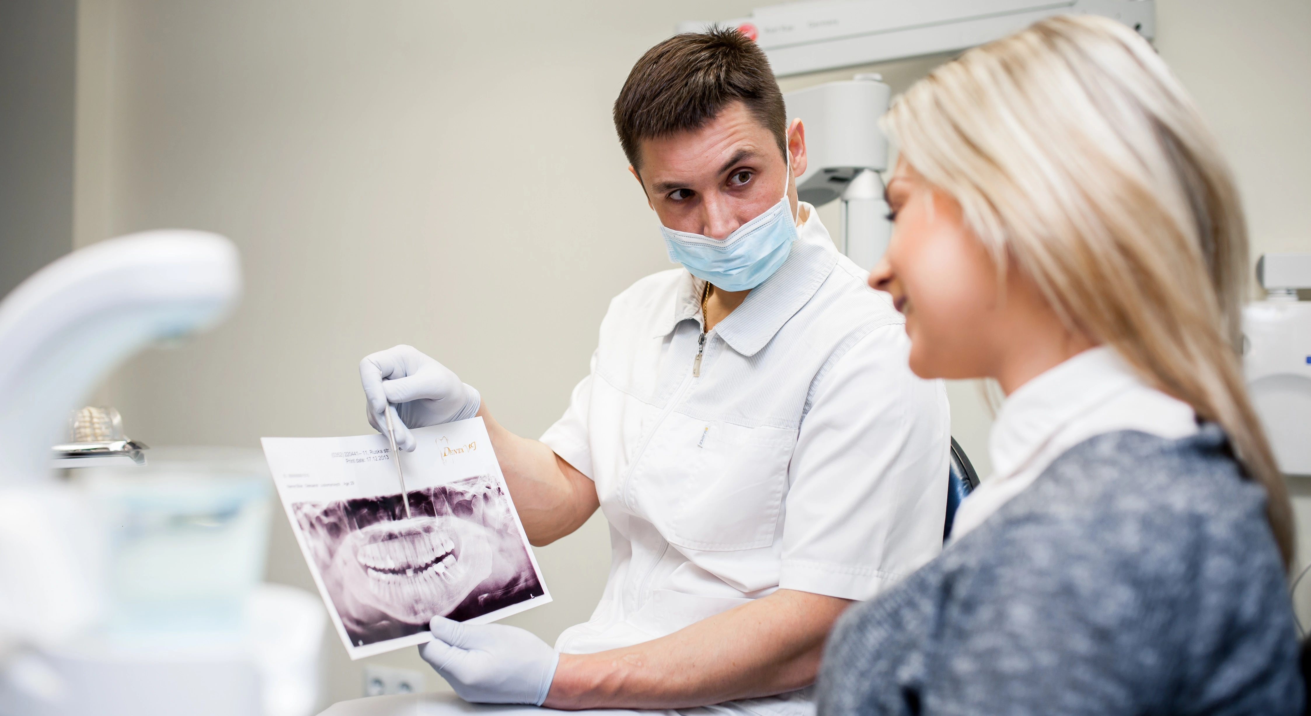 Paradontits Behandlung. Der Zahnarzt erklärt am Röntgenbild den durchzuführenden Eingriff.
